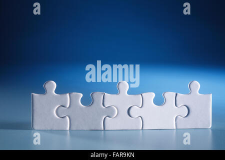 Five puzzle pieces arranged together. Stock Photo