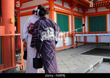 Two women in Japan taking a photo using a smartphone and selfie stick. Stock Photo