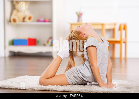 Little Girl Lying On The Floor And Doing Stretching Exercises With Her  Teacher At Studio Stock Photo, Picture and Royalty Free Image. Image  65119506.