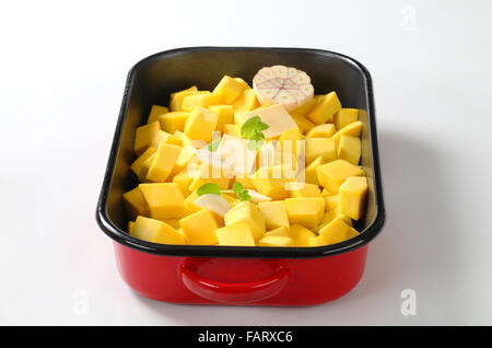 fresh pumpkin cubes with garlic and butter in a baking pan Stock Photo