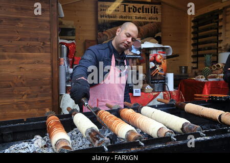 Cooking and selling 'trdelnik', the traditional Czech cake and sweet pastry on the Christmas market in Prague Castle Stock Photo
