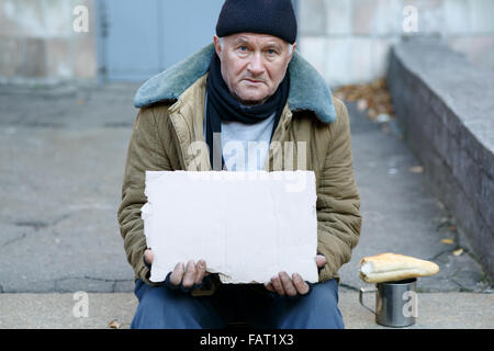 Homeless man holding a cardboard sign. Stock Photo