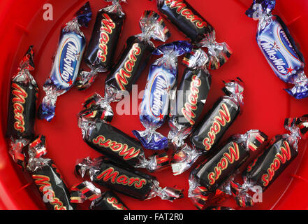 Milky Way and Mars fun size bars left in the bottom of a tub of chocolates. Stock Photo