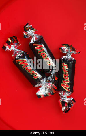 Mars fun size bars left in the bottom of a tub of chocolates. Stock Photo