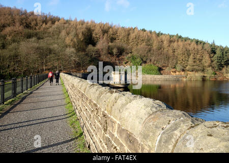 Two people walk along the dam wall of the Ladybower reservoir, Upper Derwent Valley, Derbyshire, England, UK Stock Photo