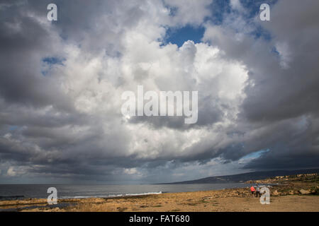 Cyprus, Pafos, Couple walking on beach. Dark clouds Stock Photo
