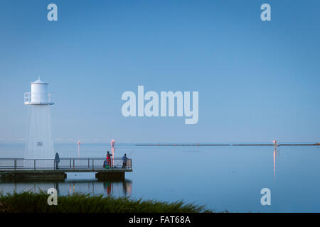 As the sun sets some locals fish near the mouth of the Mersey River in Devonport, Tasmania. Stock Photo