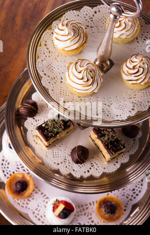 A selection of delicious desserts arranged and served on a silver cake stand in an english high tea style. Stock Photo