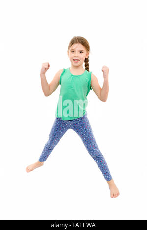 young girl wearing blue leggings and green vest doing exercises on white background Stock Photo