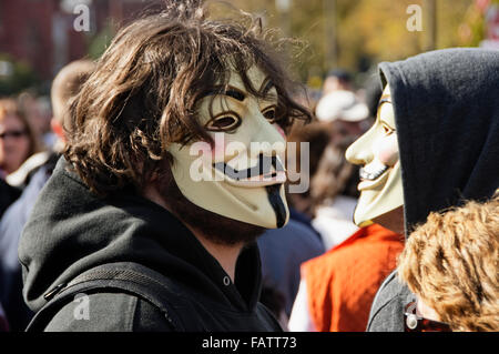 Two young male demonstrators wear Guy Fawkes masks during a public demonstration. Stock Photo