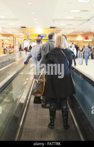 Passengers on moving walkway in airport Stock Photo