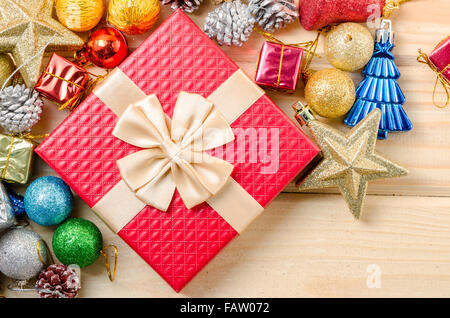 Red gift box and christmas decorations on wooden background. Stock Photo