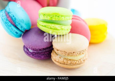 Colorful macaroons in white cup on wooden background. Stock Photo