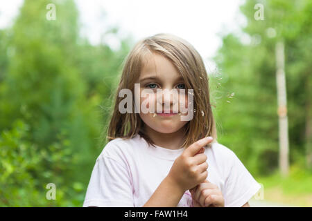 Portrait of a young girl outdoors in the summer chewing a grass straw  Model Release: Yes.  Property Release: No. Stock Photo
