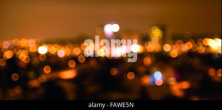 Abstract colorful defocused city lights with bokeh effects at night. Warm tone orange light background. Stock Photo