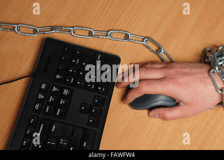 the man chained to the workplace, working at a computer Stock Photo