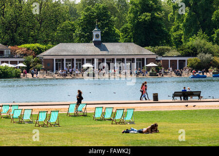 People in relaxing on lawns in deckchairs in Hyde Park in summer. Stock Photo