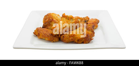 Side view of a serving of buffalo style chicken wings on a square plate isolated on a white background. Stock Photo