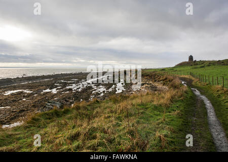 Coast walking footpath between St Monan's and Pittenweem on the coast of Fife in Scotland. Windmill in the distance. Stock Photo