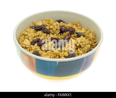 A dry mix of fruit and assorted nuts granola cereal in a colorful bowl isolated on a white background. Stock Photo