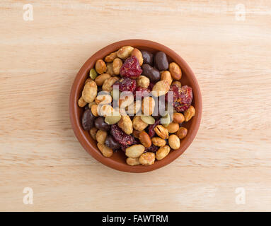 Top view of a portion of trail mix with soy beans, dried cranberries and pumpkin seeds sprinkled with sea salt in a small bowl Stock Photo