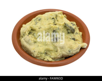 A portion of freshly made packaged spinach hommus in a small bowl isolated on a white background. Stock Photo