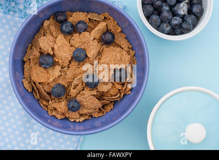 A healthy breakfast of cereal, bran flakes and blueberries. Shot from above looking down onto the table. Stock Photo