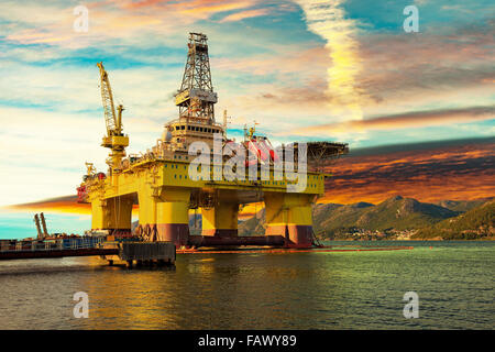 Oil drilling rig in sunset time. Stock Photo