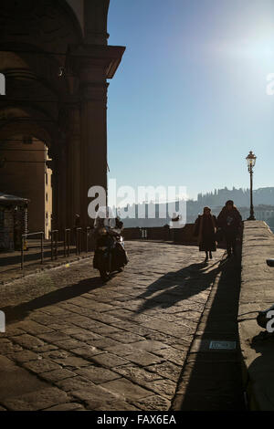 Moped rider along the Lungarno degli Archibusieri in Florence, Italy Stock Photo