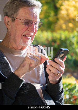 Elderly male using cell phone Stock Photo
