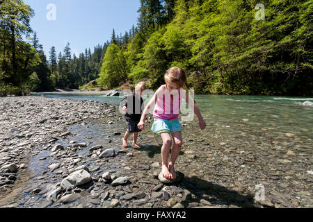 Children playing barefoot in water, South Fork Trinity River, Northern California Stock Photo