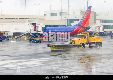 Snow plow truck clears the snow from taxiway at Denver International Airport, Denver, Colorado, USA Stock Photo