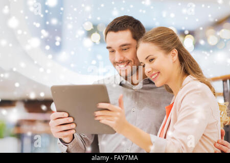 happy couple with tablet pc taking selfie in mall Stock Photo
