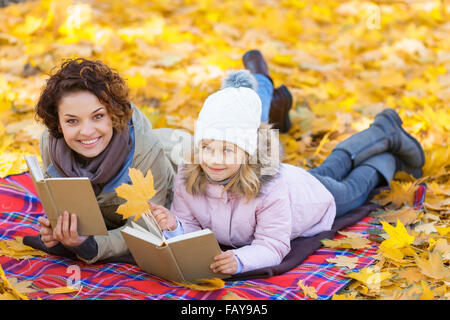 Positive mother and daughter reading books Stock Photo