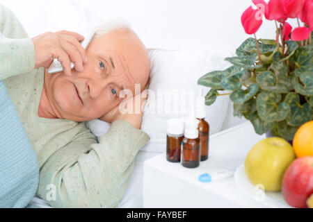 Worried elderly patient is calling somebody. Stock Photo