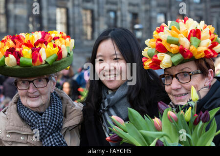 Netherlands, Amsterdam, Start tulip season. Dam Square. National Tulip Day. Two ladies with tulip hats and tourist Stock Photo