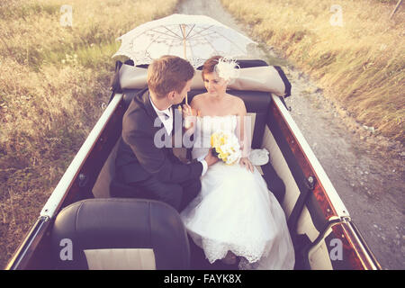 Bride and groom in a vintage car Stock Photo