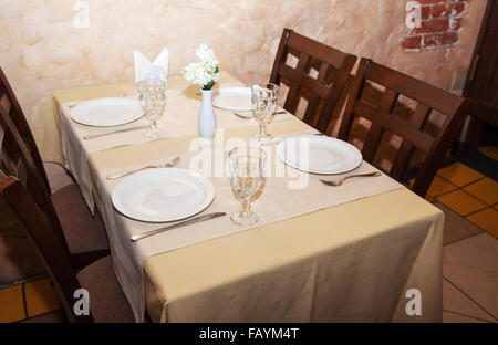 wineglasses and plates on table in restaurant Stock Photo