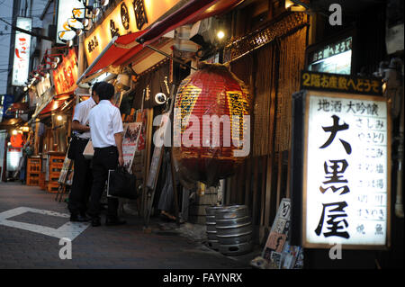 two men at the entrance of a traditional Japanese restaurant in the district of Asakusa Tokyo Japan Stock Photo