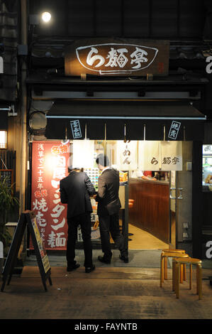 two business men at the entrance of a Japanese restaurant in Asakusa Tokyo Japan Stock Photo