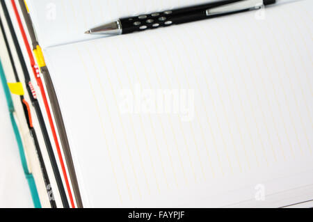 Blank notebook open on stack of book with pen Stock Photo