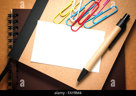 White paper card on notebook with pen on kraft cardboard background Stock Photo