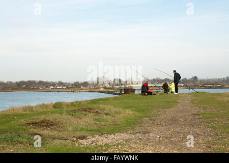 Group of fishermen at Langstone harbour fishing from the path of the old Hayling Billy railway track Stock Photo