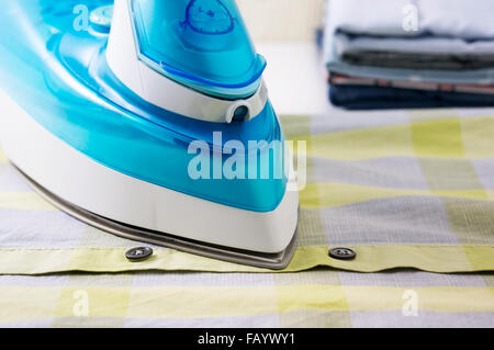 Ironing clothes with blue iron and shirts Stock Photo