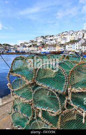 Lobster pots on the New Quay, Brixham, Devon, on a glorious summer's day; the town rises in the background over the harbour Stock Photo