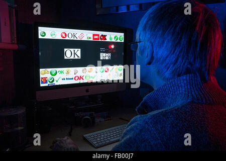 Man at computer with 'OK' written on screen. Stock Photo