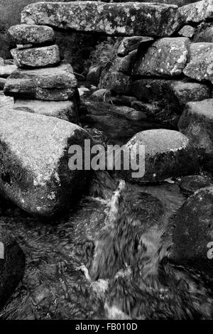 The remains of the ancient clapper bridge at Dartmeet, Dartmoor, Devon which crossed the East Dart River Stock Photo