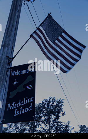 Welcome sign and American flag as you enter the town of Madeline Island (dark colors) Stock Photo