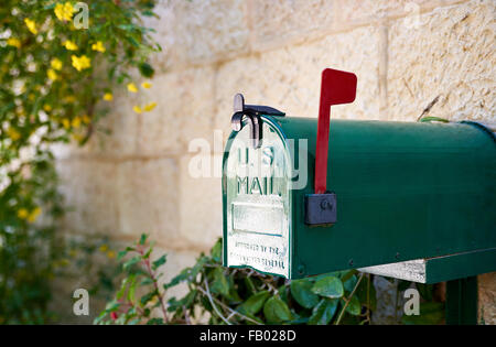 Green US post mail letter box with red flag raised up Stock Photo