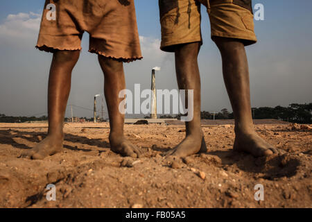 Dhaka, Bangladesh. 23rd Nov, 2015. Child workers stand in a brickfield barefoot with no shoes. Workers work here from dawn to dusk and their wages are often not up to the minimum standard. These children work here for as little as $1.5 USD per day. They are growing up without any education. (Credit Image: © Mohammad Ponir Hossain/zReportage.com via ZUMA Press) Stock Photo